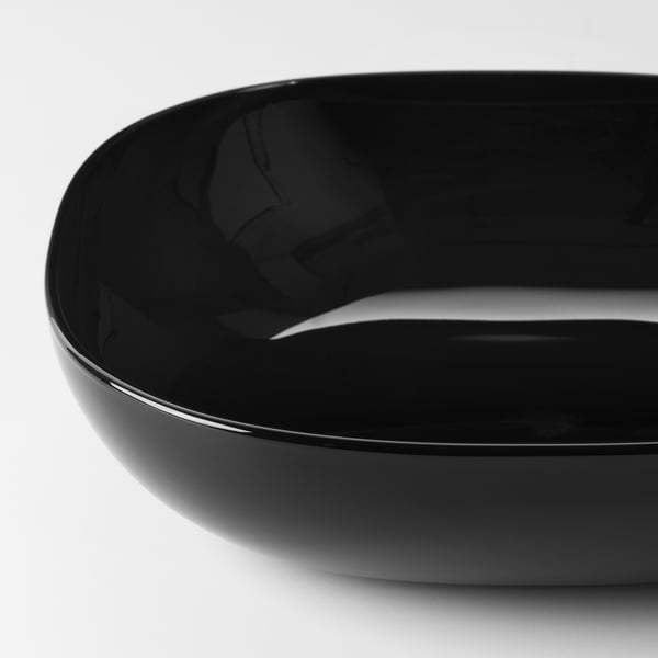 Round black glass bowl with glossy finish, set against a plain white background.