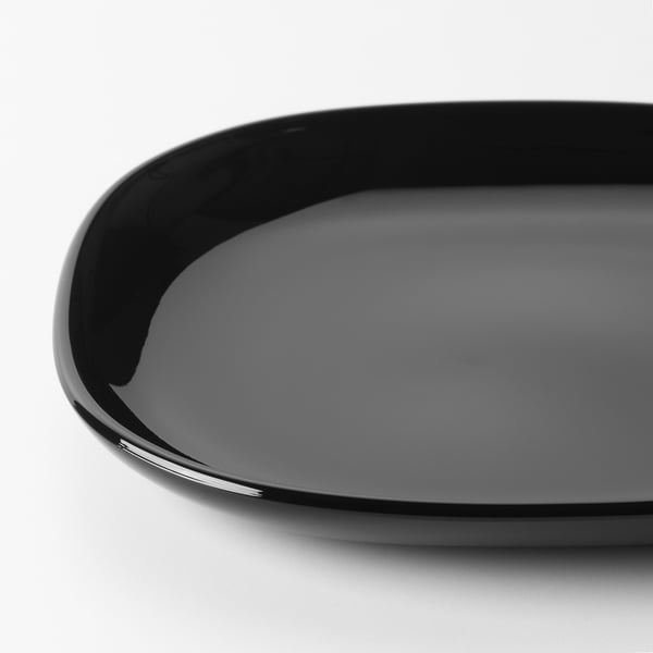 Black glossy dinnerware made of tempered glass, reflecting light smoothly, showing its durability and elegant design.