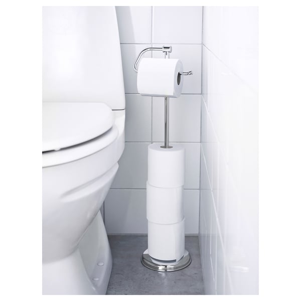 Chrome toilet paper holder with 3 rolls, magnetic fitting for easy roll change, stands beside a white toilet.