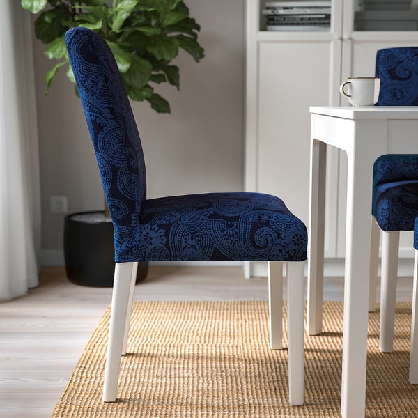 Blue paisley-patterned chair with white legs near a table, showcasing its removable, machine-washable cover for easy cleaning.