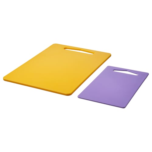 Yellow & purple cutting boards with handles on a flat surface.