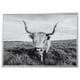 Black and white photograph of a long-horned highland cattle in a grassy field, framed in a sleek silver BJÖRKSTA frame.