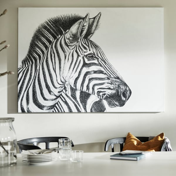 Large zebra wall art above modern dining table with chairs, featuring monochrome artwork, white canvas, and sleek black chairs.