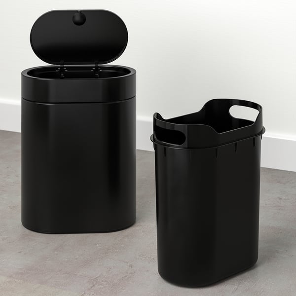 Two black rubbish bins, one with an open lid, designed for narrow spaces and easy waste bag handling.