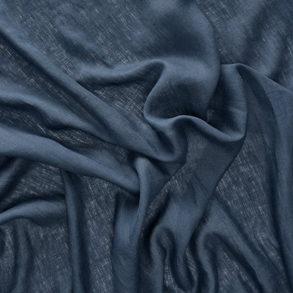 Close-up of wrinkled dark blue linen, showcasing its texture and quality.