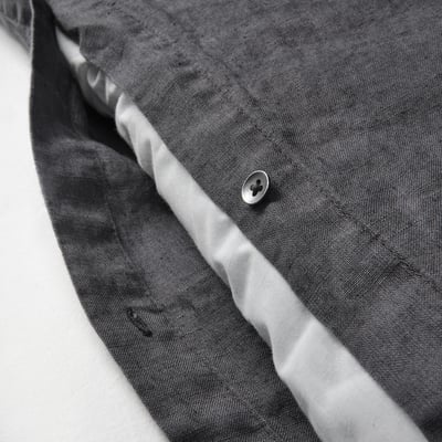 Close-up of grey linen duvet with button. Pre-washed for softness and casual look.