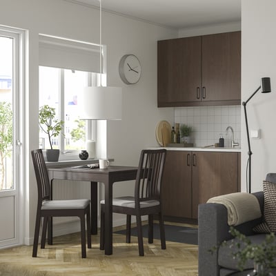 Modern dining with EKEDALEN dark wood table, 2 light grey chairs, kitchen, window, and black floor lamp.