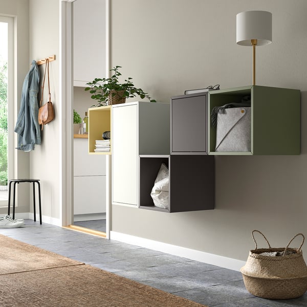 Colourful EKET cabinets in entryway with open & closed storage, rug, basket, coat hooks.