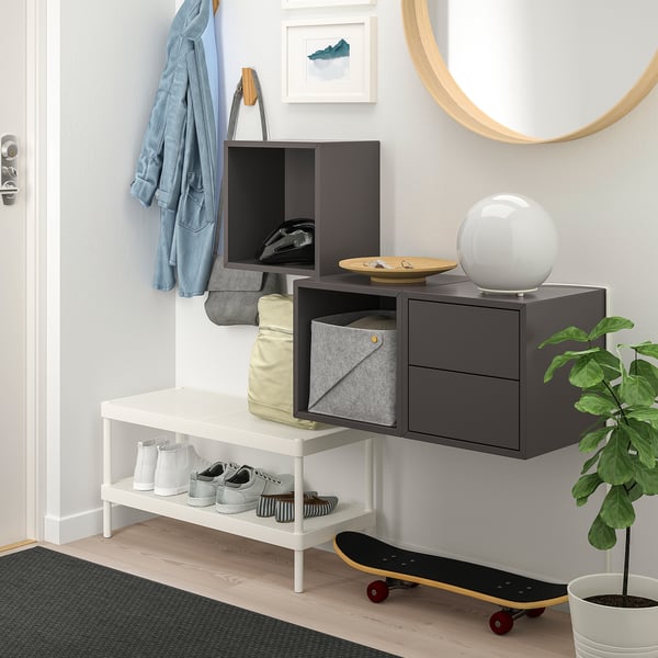 Modern entryway with EKET storage combo. White bench, grey cabinets, hanging jackets, skateboard, plant.
