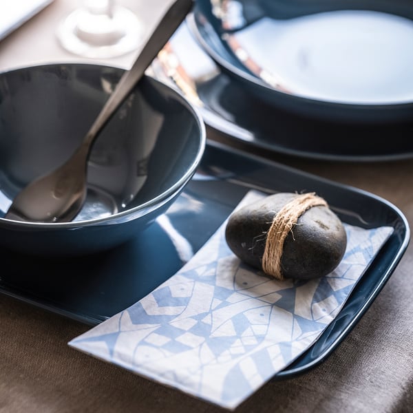 Dark grey bowl and plate set on a table with patterned napkin, showcasing modern minimalist design.