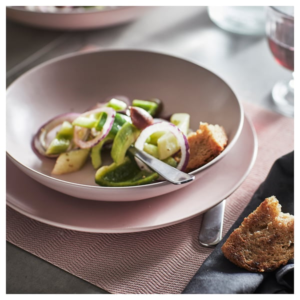 A stylish stoneware plate in pastel colour, featuring a salad and bread on a textured placemat, perfect for casual dining.