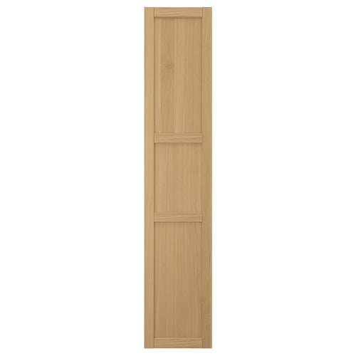 A FORSBACKA kitchen cabinet door in warm oak veneer. It a classic framed design with bevelled edges and a natural wood look.
