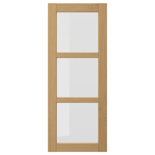 The FORSBACKA kitchen cabinet a warm oak finish with glass doors framed in bevelled edges, exuding a classic, traditional style.