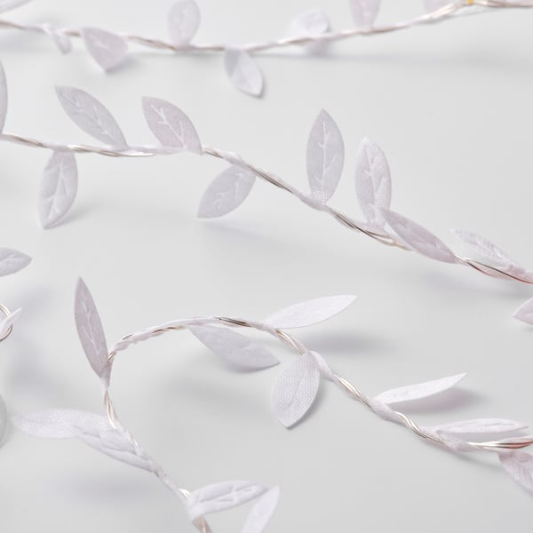 Image shows a decorative led light chain with white leaves and small diodes, designed to create a warm, festive ambiance.