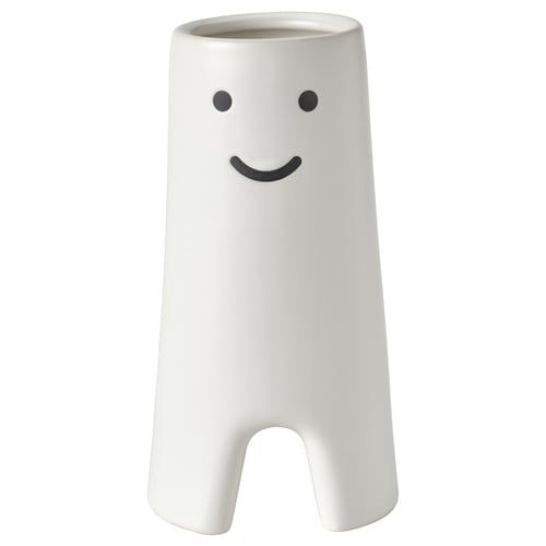 White ceramic vase with smiling face design, cylindrical shape with small cutouts at base.
