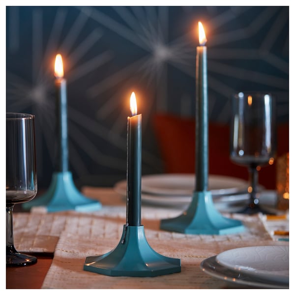 Blue glass candles in octagonal tealight holders set on a table for a festive mood.