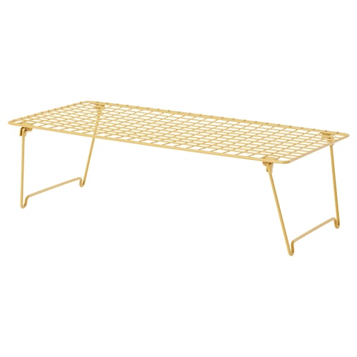 The GREJIG, a golden shoe rack, with a grid design and foldable legs made of steel.