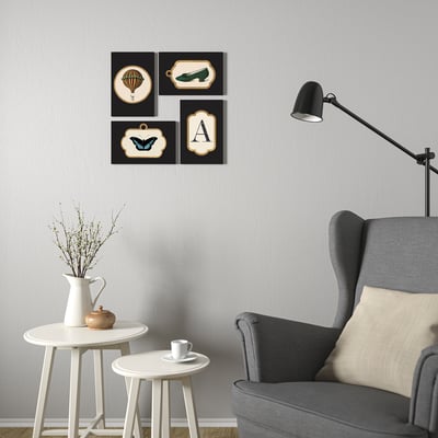 Four mixed frames above chair, lamp, side tables with decor.