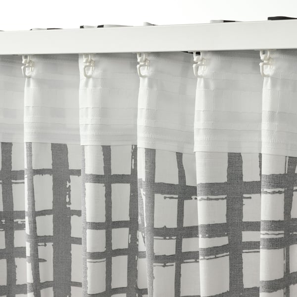 Black and white stripped curtains hang neatly, secured by hooks, filtering light and offering privacy.