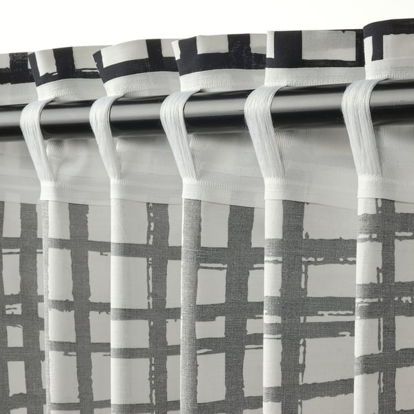 Black and white striped curtains with white heading tape looped over a silver rod, hanging evenly with soft pleats.