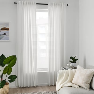 White GUNNLAUG curtains by window, with couch, plant, and painting.