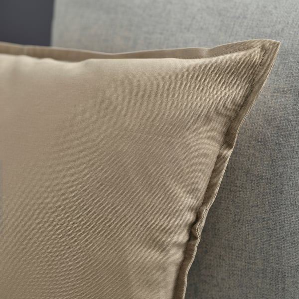 A close-up of a beige GURLI cushion with a smooth texture and hidden zip, made of high-quality cotton.