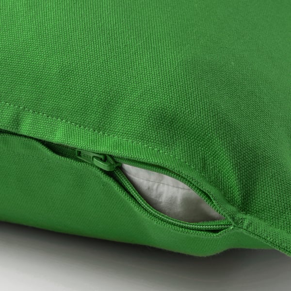 Bright green cushion cover with a hidden zip for easy removal, showcasing its soft cotton material.