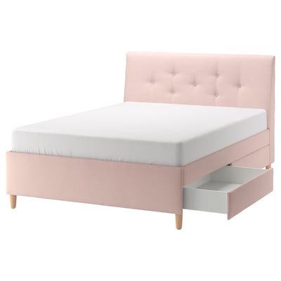A pink IDANÄS bed with a padded headboard and drawers, featuring wooden legs and a white mattress.