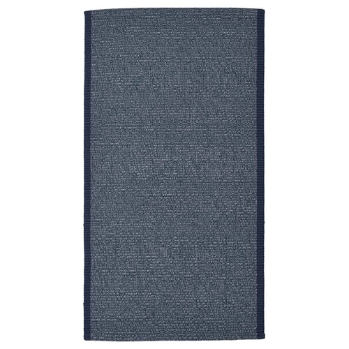 An IDROTTSPLATS rug in dark blue with white accents, rectangular shape, cotton material. It complements various floors and is easy to clean.