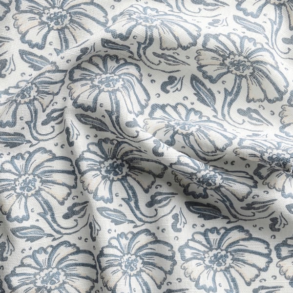 A fabric with intricate floral patterns in shades of blue and white, showcasing high quality cotton texture and detailed designs.