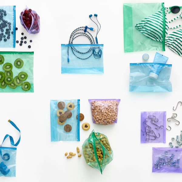 Assorted reusable zip bags with various contents like fruits, snacks, tech accessories and hardware, illustrating organisation and versatility.