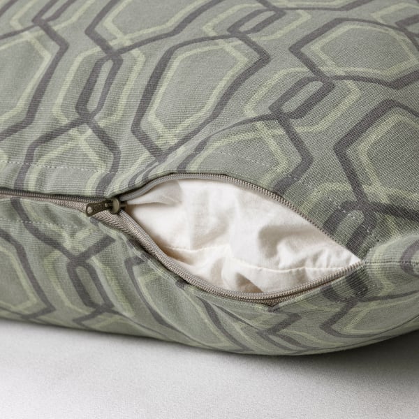 A cushion cover with a green geometric pattern and a hidden zip for easy removal.