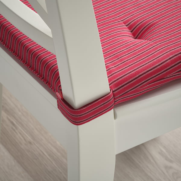 Red striped chair cushion on white chair with loop fasteners for secure fit.