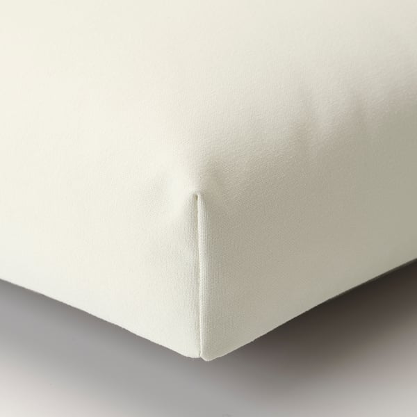 Close-up of JUTHOLMEN outdoor seat cushion, pristine white, finely woven fabric, thick & plush, showcasing high-quality stitching.