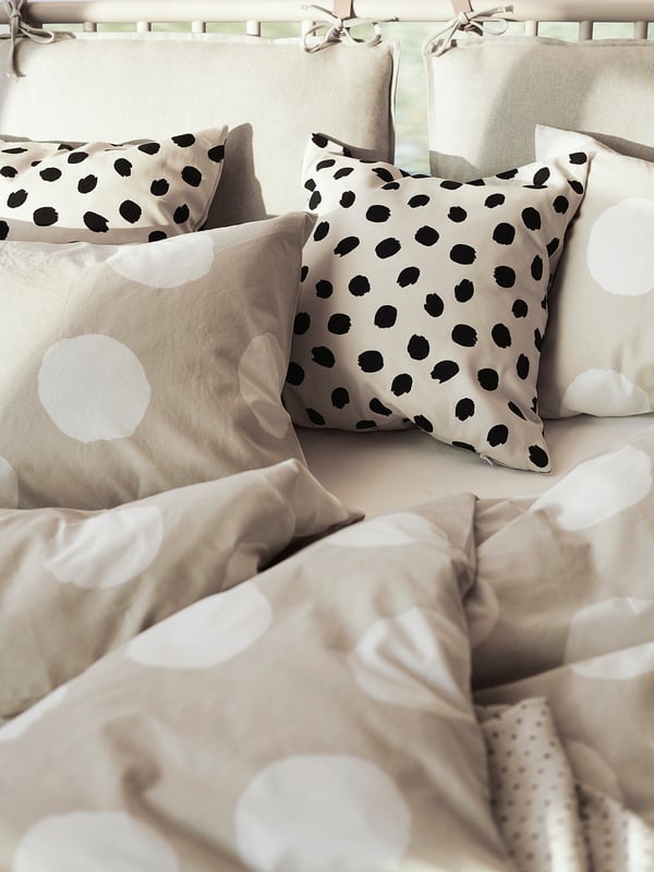 Bedding set with tan KLYNNETÅG cover, large white dots, soft cotton; includes two pillows.
