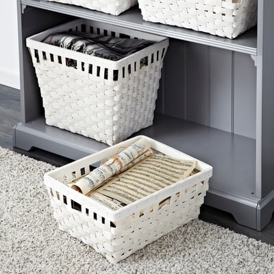 White woven baskets organising items in and out of a grey shelf.