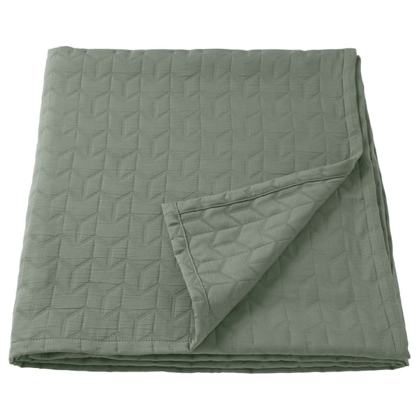 Green quilted bedspread, smooth texture, recycled polyester.