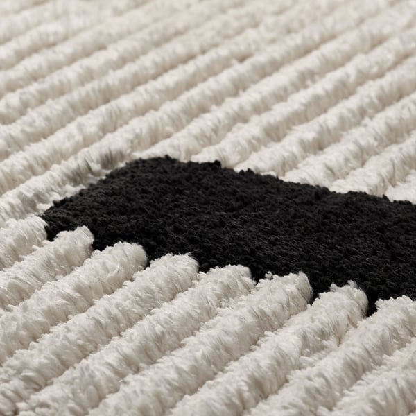 Close-up of hues rug with bold lines. Textured, high and low piles for comfort.
