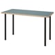 A LAGKAPTEN desk with a blue table top and black metal legs. The design is simple and rectangular with a patterned edge.