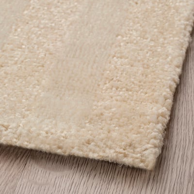 Off-white striped rug, rectangular shape, soft low pile, recycled materials.