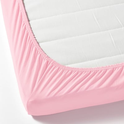 Light pink fitted sheet with elastic edge securing white mattress.