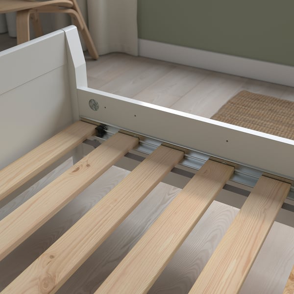 Wooden slatted bed base supports mattress, showing flat slats for even support.