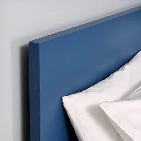 A sleek, modern blue bed with crisp white sheets, showcasing high-quality design.