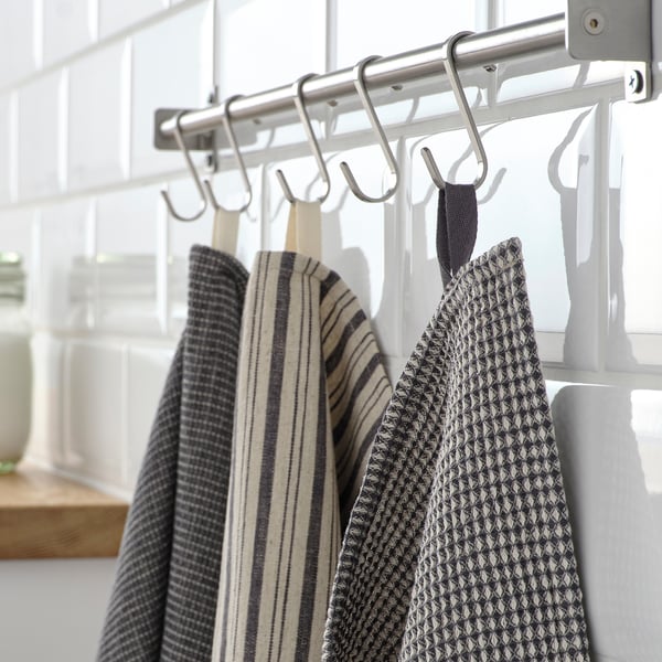 Three towels hang on hooks near a window, with patterns of stripes and dots, absorbent and made of cotton/linen blend.