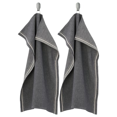 Two dark grey MARIATHERES towels hang side-by-side on hooks, made of cotton and linen blend, featuring a textured design with light grey edges.