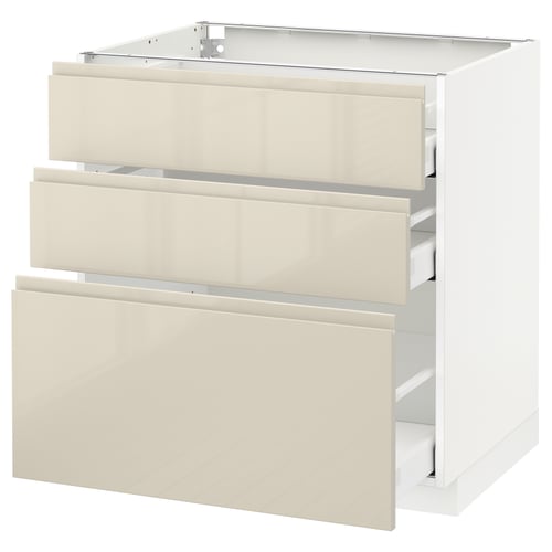 A white METOD kitchen cabinet with high gloss beige drawers featuring integrated handles. It has a modern design with three fully extendable drawers.