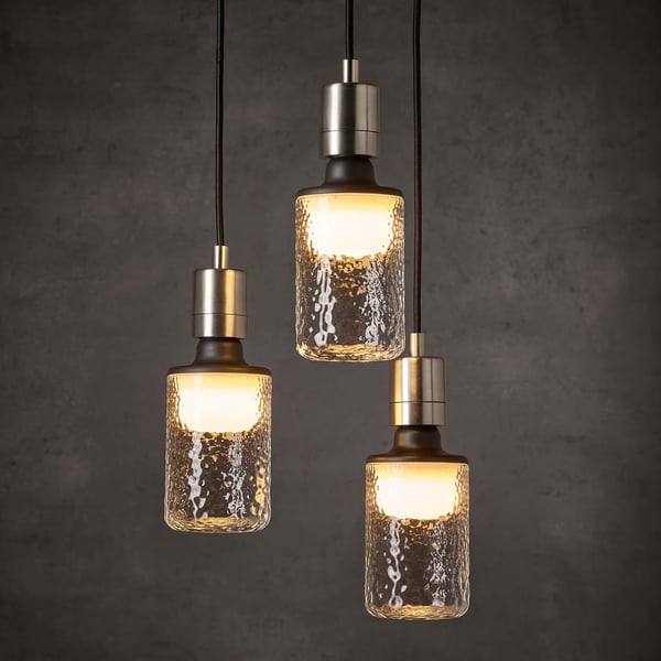 Three illuminated hanging lamps with hammered glass shades and metallic fixtures, emitting a warm glow.