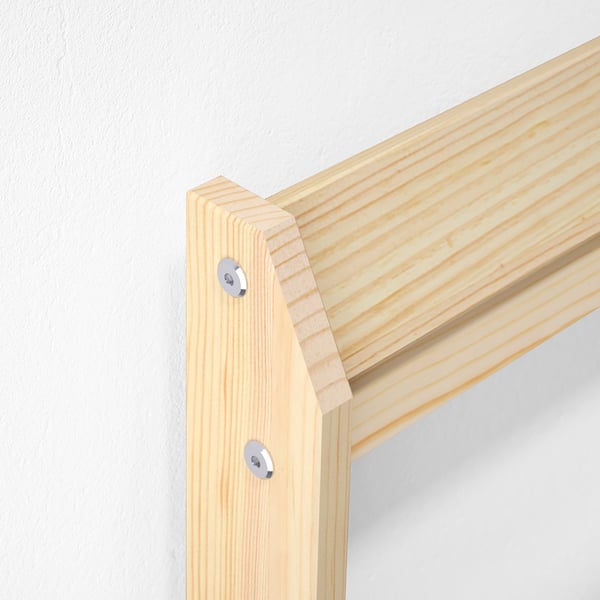 Wooden bed frame corner, showing quality craftsmanship with solid pine and metal hardware.