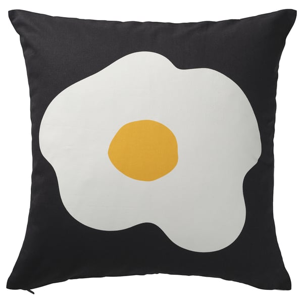 Black square pillow with large fried egg design in white and yellow.