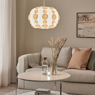 Modern living room with PEKTOLIT lamp above beige sofa and coffee table.